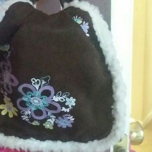 A purse that is brown and has pretty flowers on it